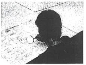 Photograph of a girl reading small print with a magnifying glass