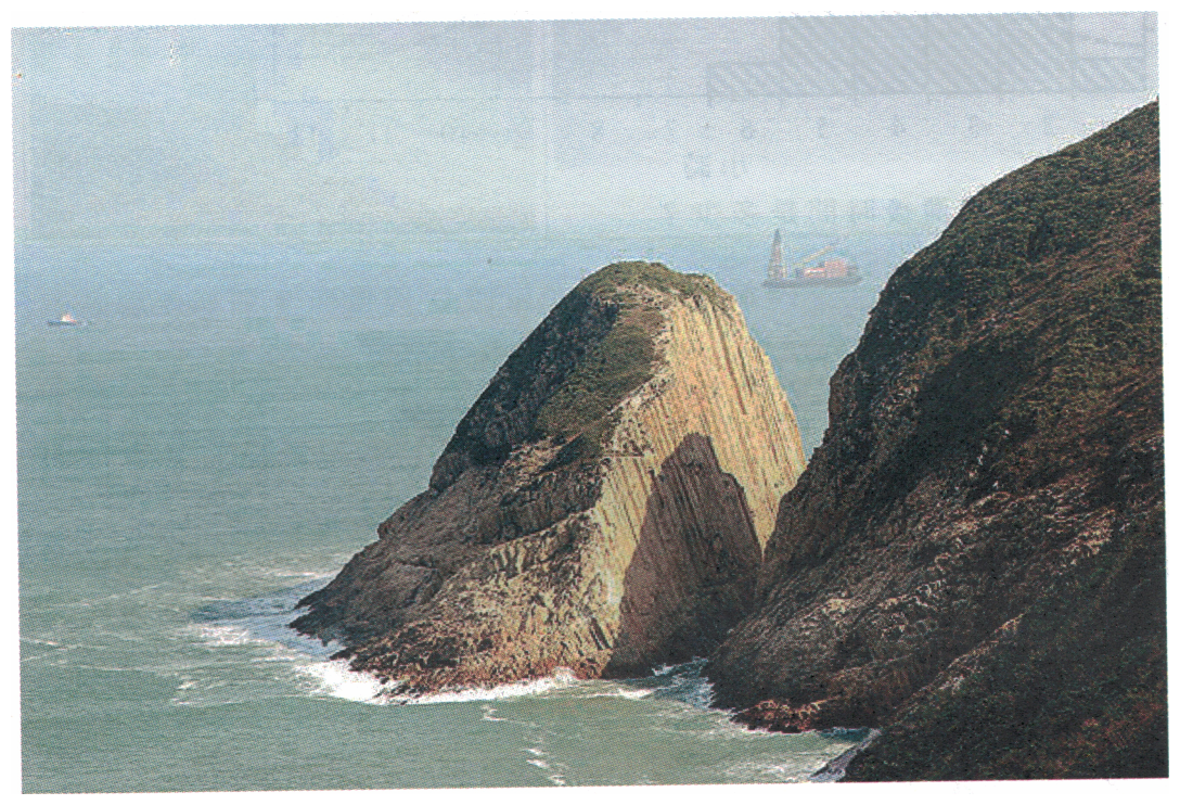 海岸岬角照片,岬角岩石呈垂直柱狀,右方為陡峭崖壁,前方為海面