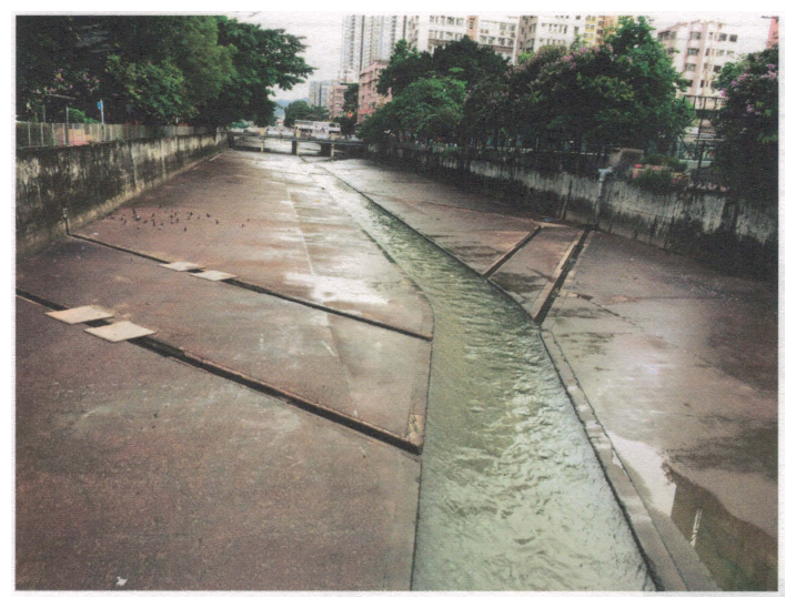 香港市區一條以混凝土鋪砌的河道照片,中間有一條窄的低水位渠道